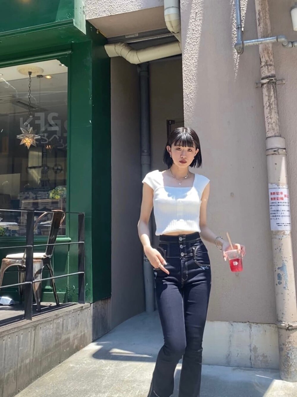 ブルー系のデニムパンツ、ホワイト系のタンクトップを着用したレディースの夏コーディネートの3枚目の写真
