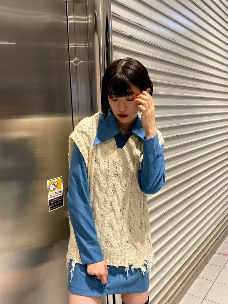 ホワイト系のベスト、ブルー系のワンピース、ブラック系のブーツを着用したレディースの夏コーディネートの7枚目の写真