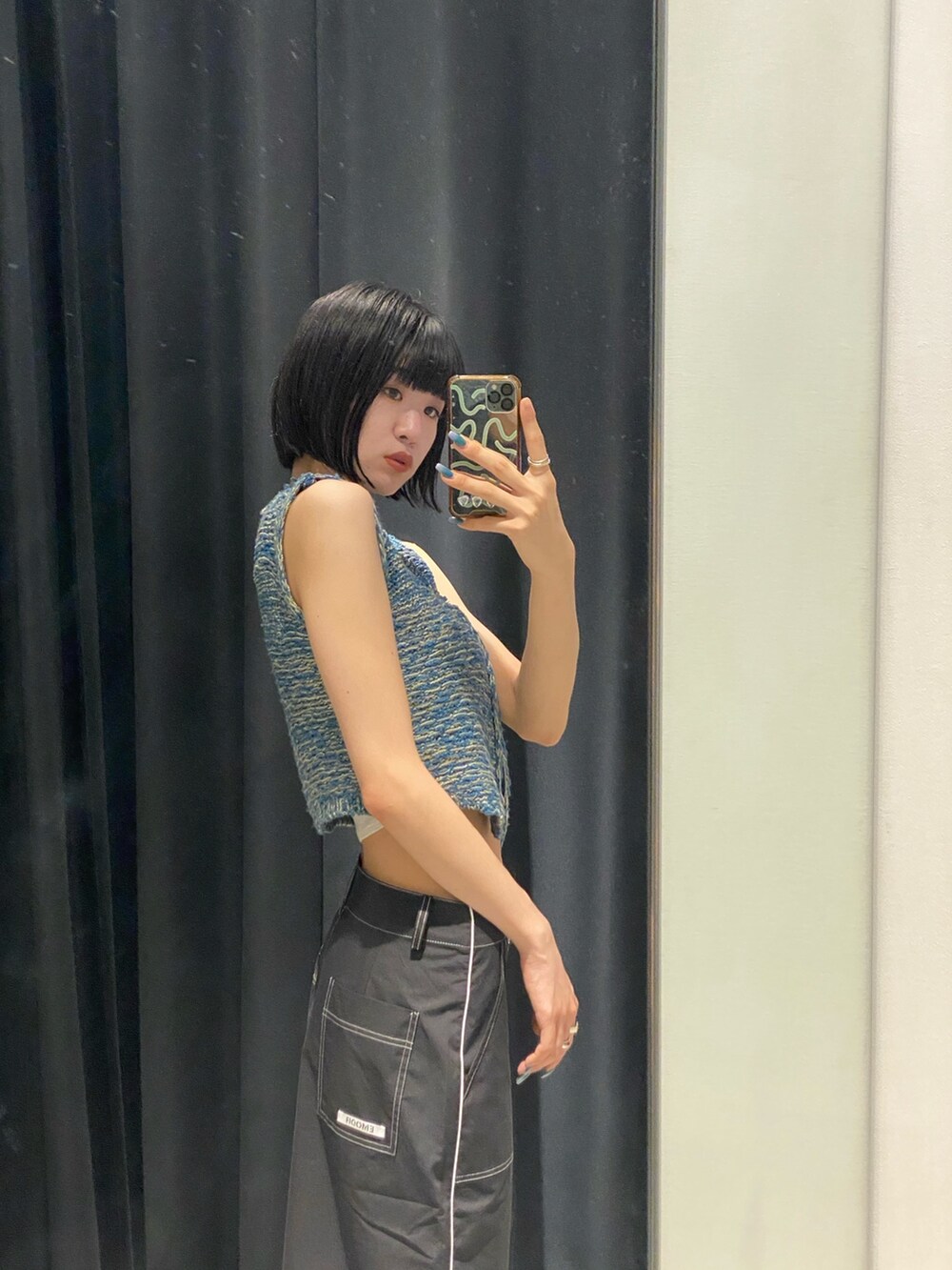 ブラック系のサンダル、ブラック系のスカート、ブルー系のベストを着用したレディースの夏コーディネートの7枚目の写真