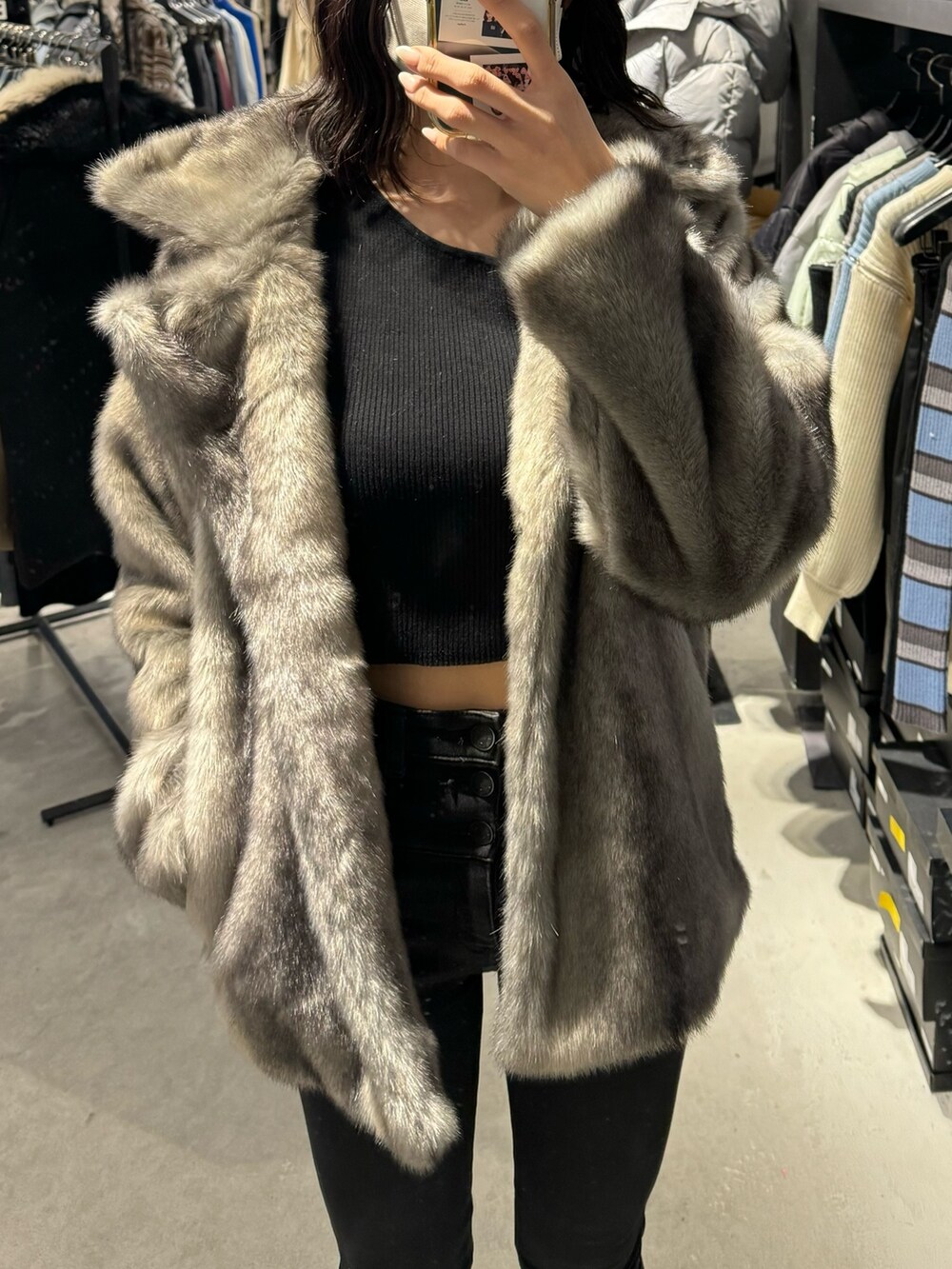 ブラック系のブーツ、ブラック系のデニムパンツ、グレー系のその他アウターを着用したレディースの冬コーディネートの3枚目の写真