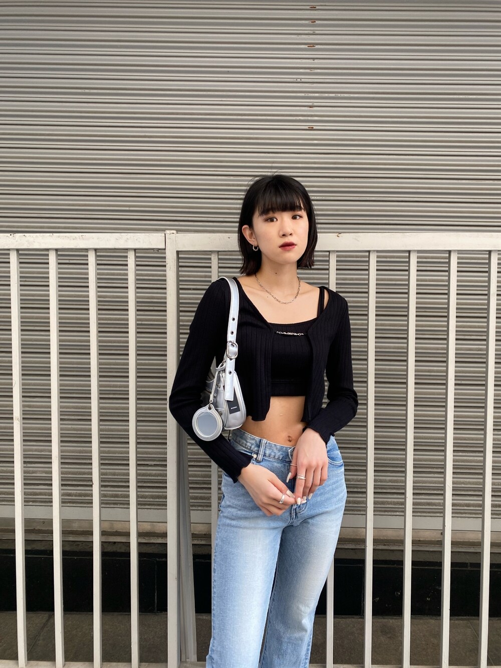 ブルー系のデニムパンツ、ブラック系のTシャツ/カットソー、シルバー系のハンドバッグを着用したレディースの春コーディネートの5枚目の写真