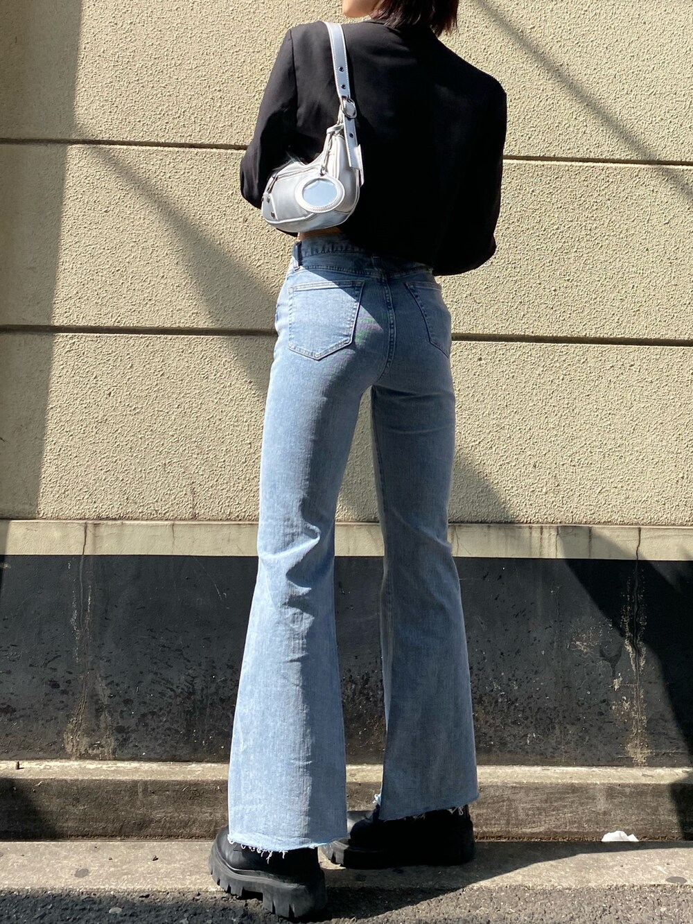 ブラック系のブーツ、ブルー系のデニムパンツ、ブラック系のTシャツ/カットソーを着用したレディースの春コーディネートの5枚目の写真