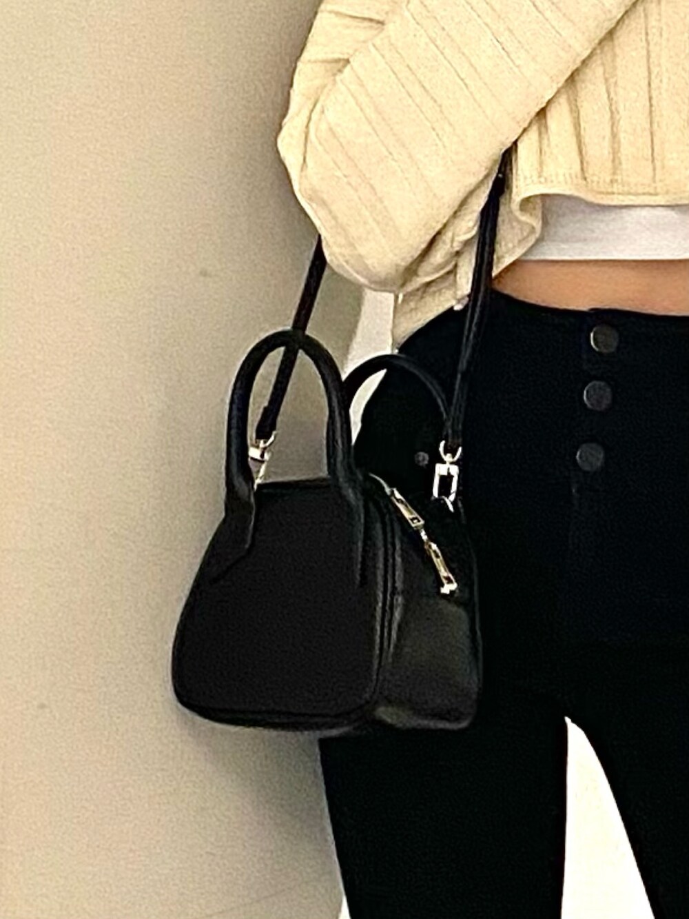 ブラック系のブーツ、ブラック系のデニムパンツ、ホワイト系のニット/セーターを着用したレディースの春コーディネートの7枚目の写真