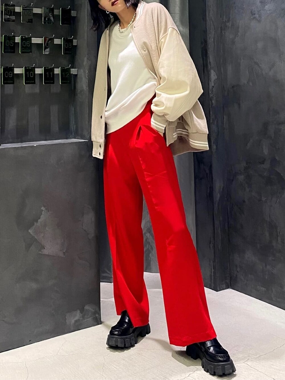 ホワイト系のブルゾン、ブラック系のローファー、レッド系のその他パンツを着用したレディースの秋コーディネートの3枚目の写真