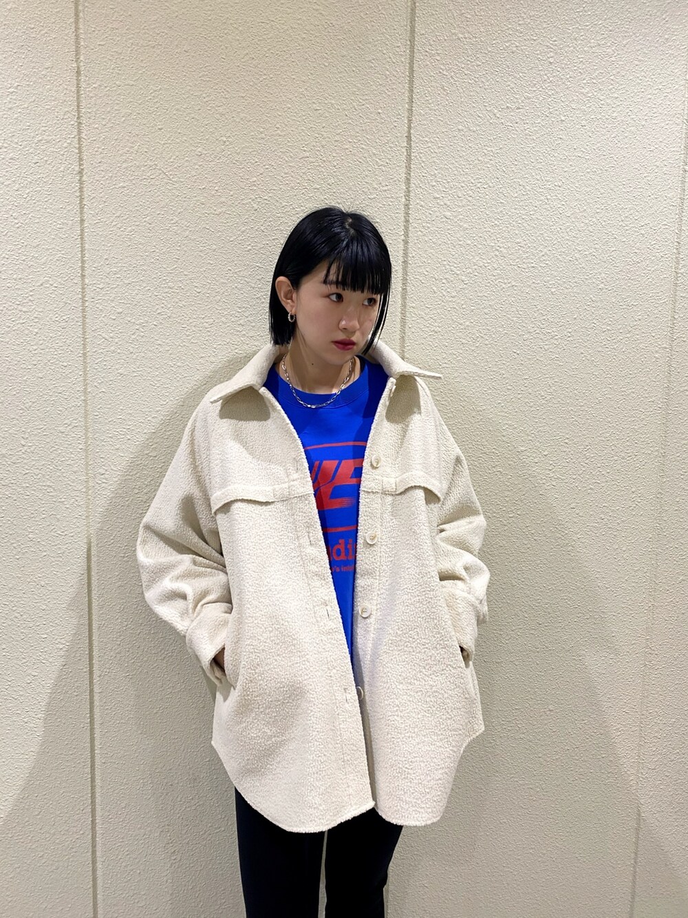 ホワイト系のブルゾン、ブラック系のその他パンツ、ブラック系のブーツを着用したレディースの冬コーディネートの6枚目の写真