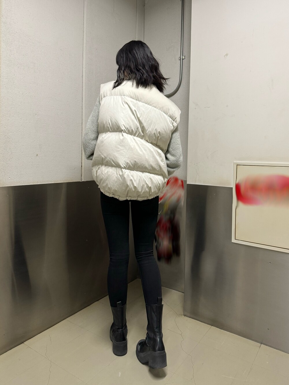 ブラック系のブーツ、ブラック系のデニムパンツ、グレー系のニット/セーターを着用したレディースの冬コーディネートの8枚目の写真