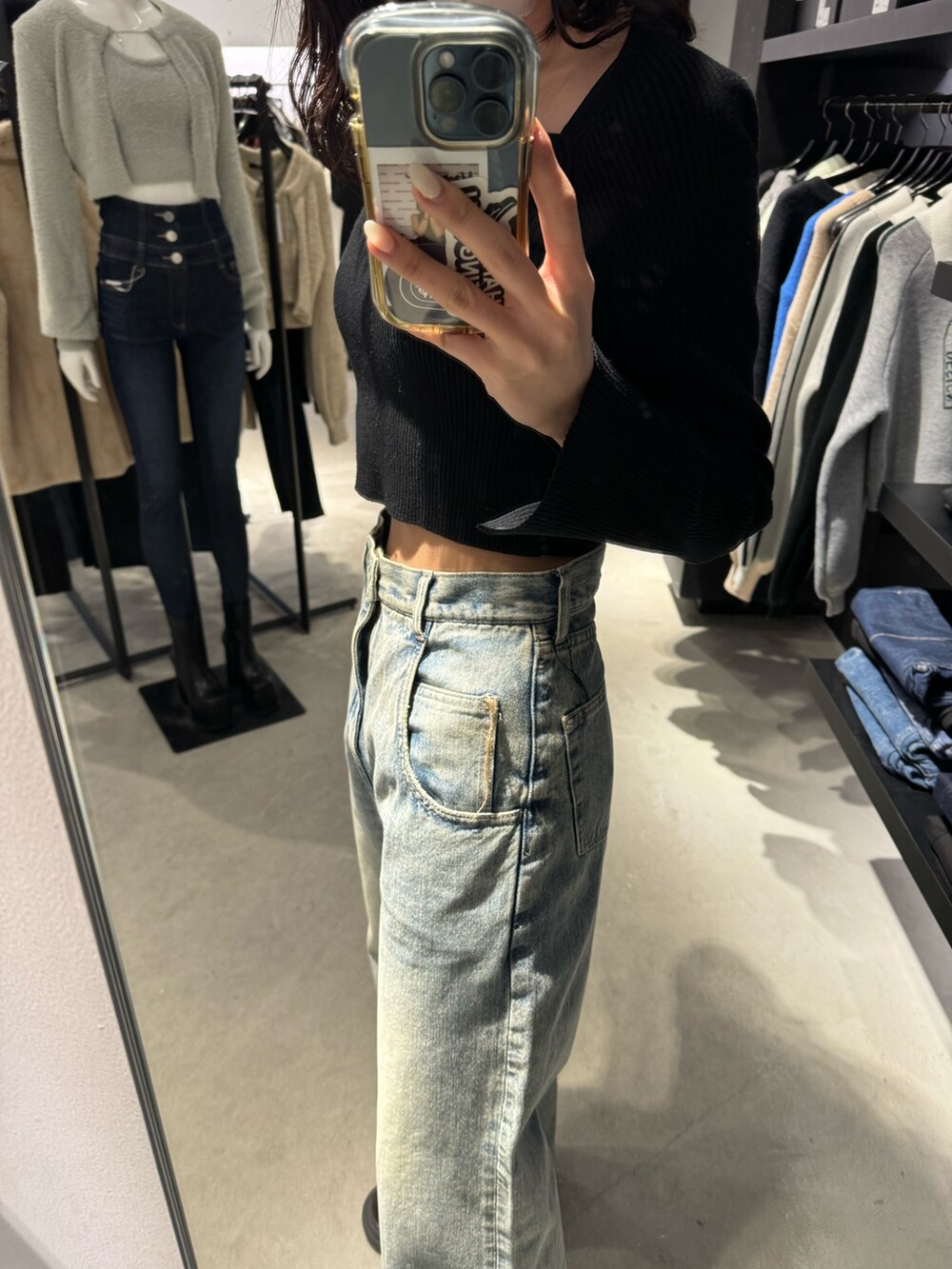 ブラック系のブーツ、ブルー系のデニムパンツ、ブラック系のニット/セーターを着用したレディースの冬コーディネートの6枚目の写真