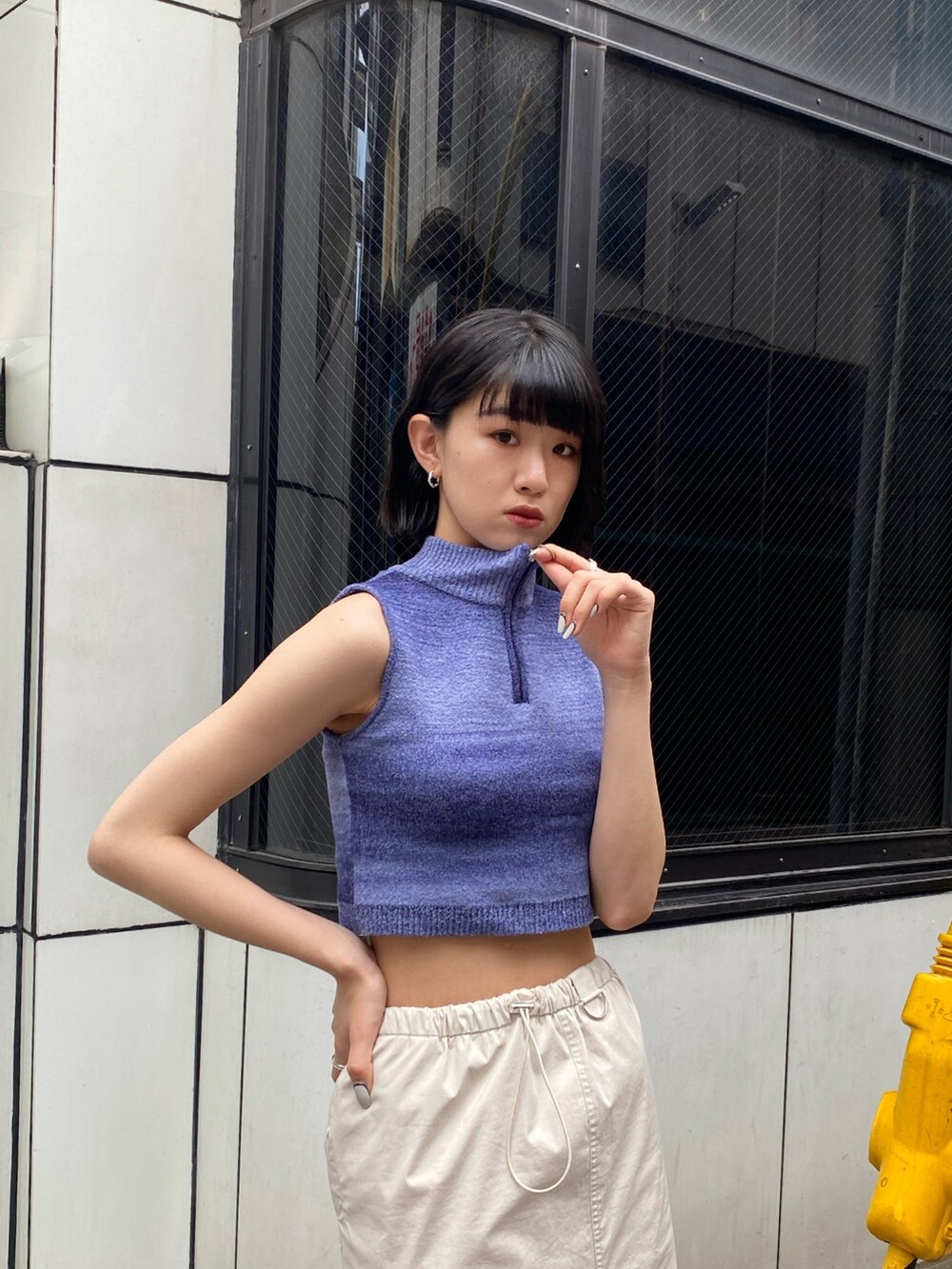 ホワイト系のブーツ、ホワイト系のスカート、ブルー系のタンクトップを着用したレディースの春コーディネートの6枚目の写真