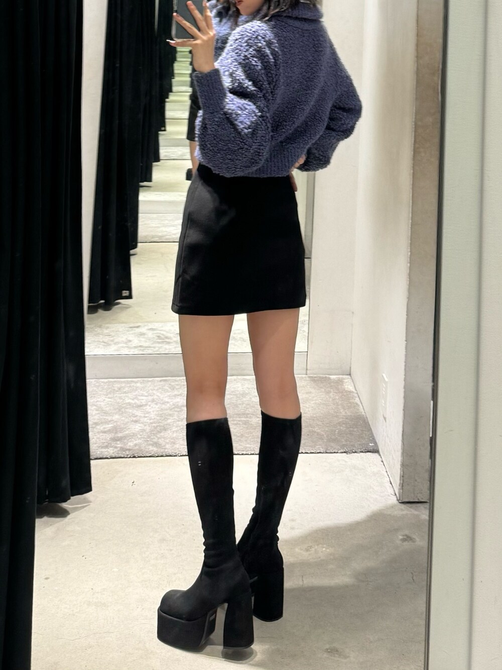 その他のブーツ、ブラック系のスカート、ブルー系のニット/セーターを着用したレディースの秋コーディネートの3枚目の写真