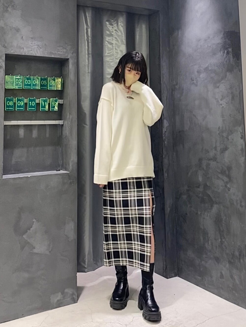 その他のスカート、ホワイト系のニット/セーター、ブラック系のブーツを着用したレディースの冬コーディネートの2枚目の写真