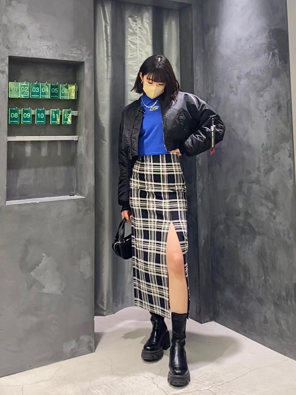 その他のスカート、ブラック系のブーツ、ブラック系のハンドバッグを着用したレディースの冬コーディネートの2枚目の写真