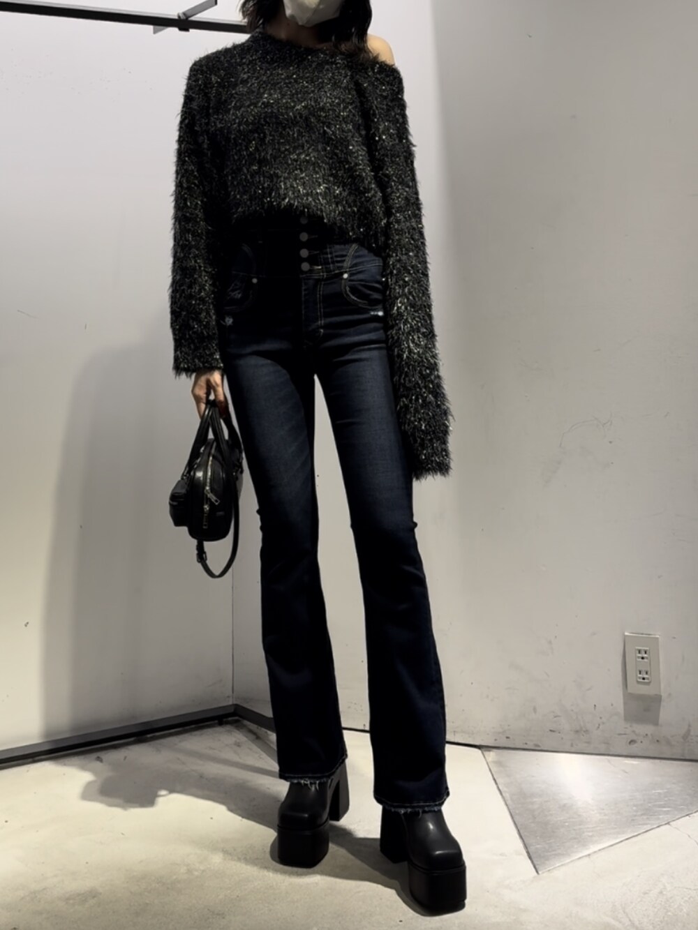 ブラック系のハンドバッグ、ブラック系のニット/セーター、ブルー系のデニムパンツを着用したレディースの冬コーディネートの5枚目の写真