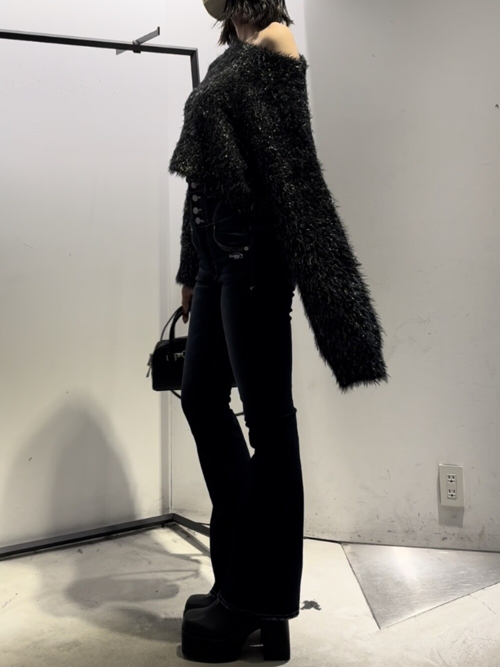 ブラック系のハンドバッグ、ブラック系のニット/セーター、ブルー系のデニムパンツを着用したレディースの冬コーディネートの7枚目の写真