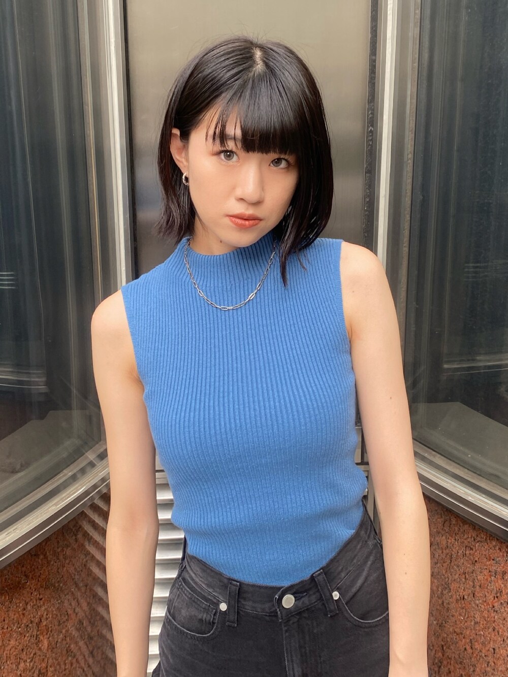 ブラック系のブーツ、ブラック系のデニムパンツ、ブルー系のニット/セーターを着用したレディースの秋コーディネートの6枚目の写真