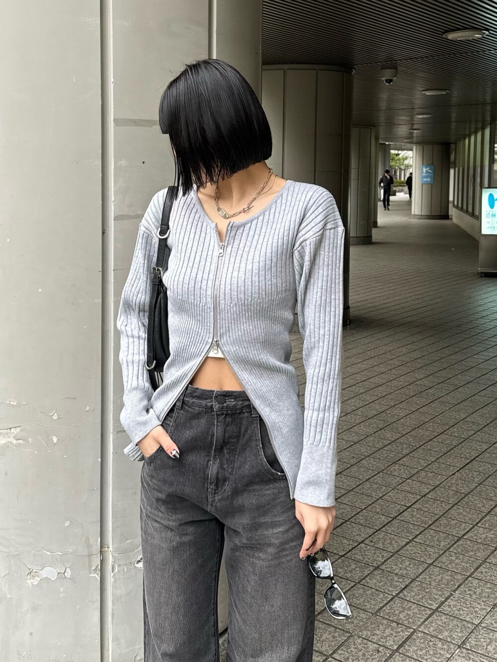 ブラック系のブーツ、ブラック系のデニムパンツ、グレー系のニット/セーターを着用したレディースの冬コーディネートの5枚目の写真