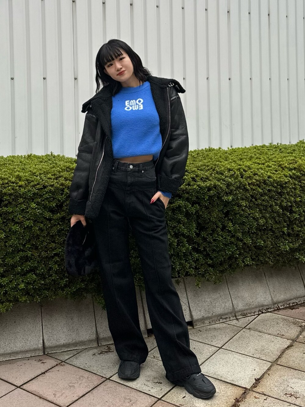 ブラック系のデニムパンツ、ブラック系のハンドバッグ、ブラック系のムートンコートを着用したレディースの冬コーディネートの2枚目の写真