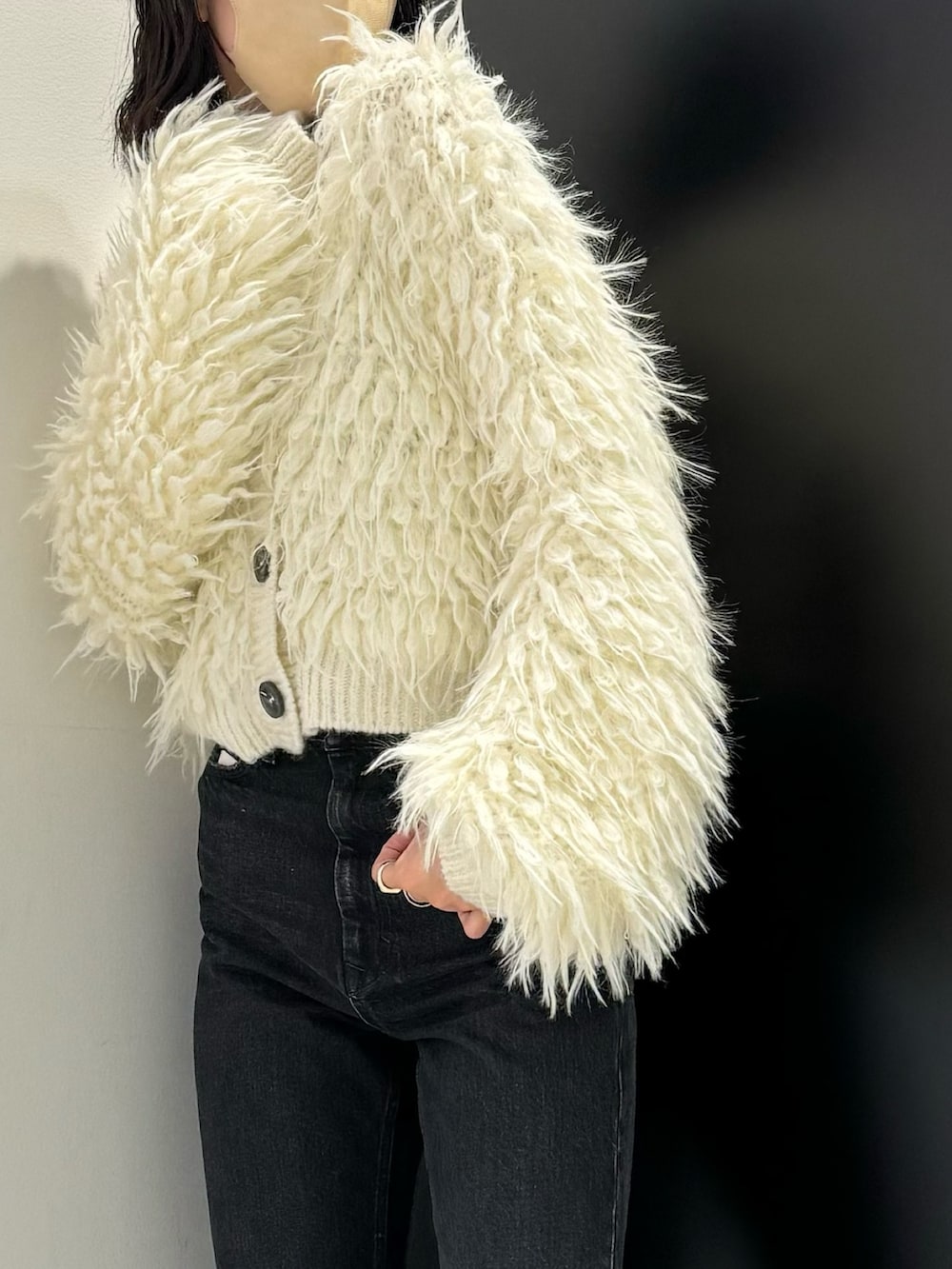 ブラック系のデニムパンツ、ホワイト系のカーディガン/ボレロを着用したレディースの秋コーディネートの4枚目の写真