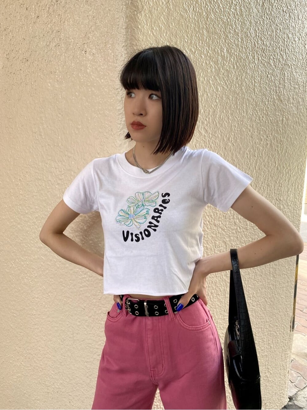 ピンク系のデニムパンツ、ホワイト系のTシャツ/カットソー、ブラック系のサンダルを着用したレディースの夏コーディネートの4枚目の写真