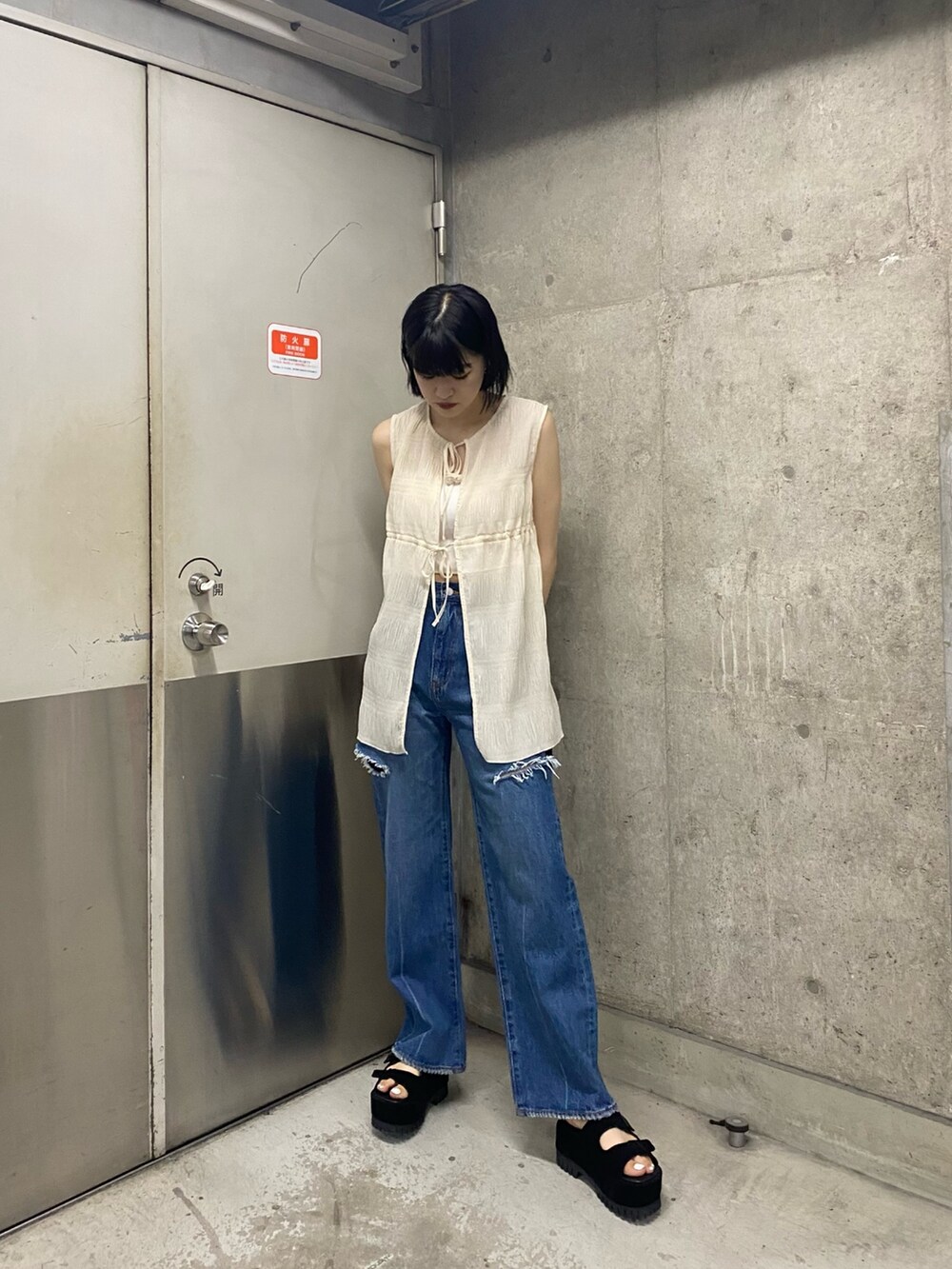 ブラック系のサンダル、ブルー系のデニムパンツ、ホワイト系のTシャツ/カットソーを着用したレディースの夏コーディネートの3枚目の写真