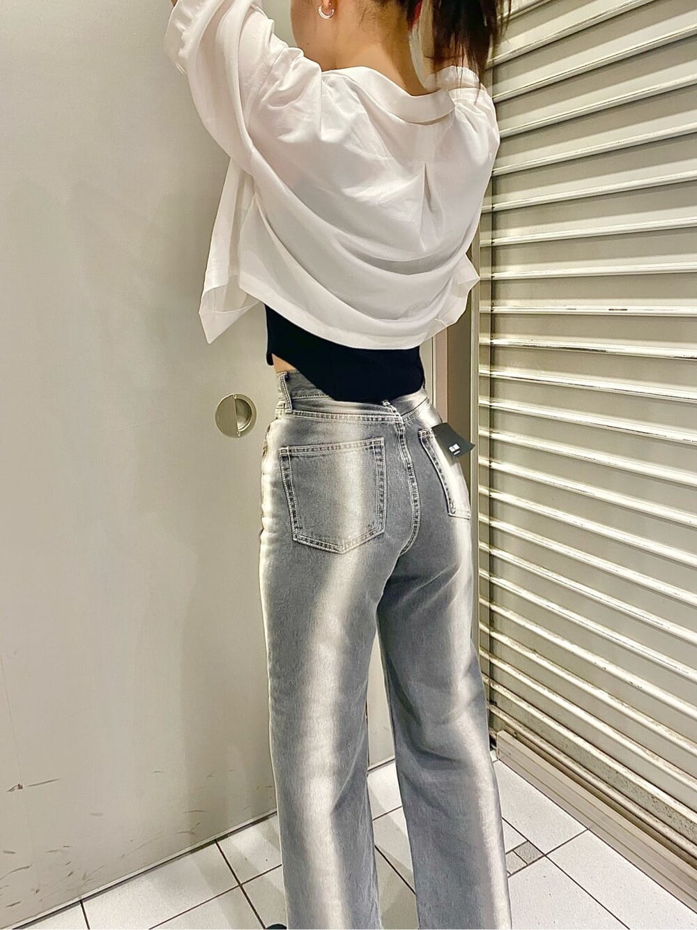 ブラック系のデニムパンツ、ブラック系のタンクトップ、ホワイト系のシャツ/ブラウスを着用したレディースの春コーディネートの4枚目の写真