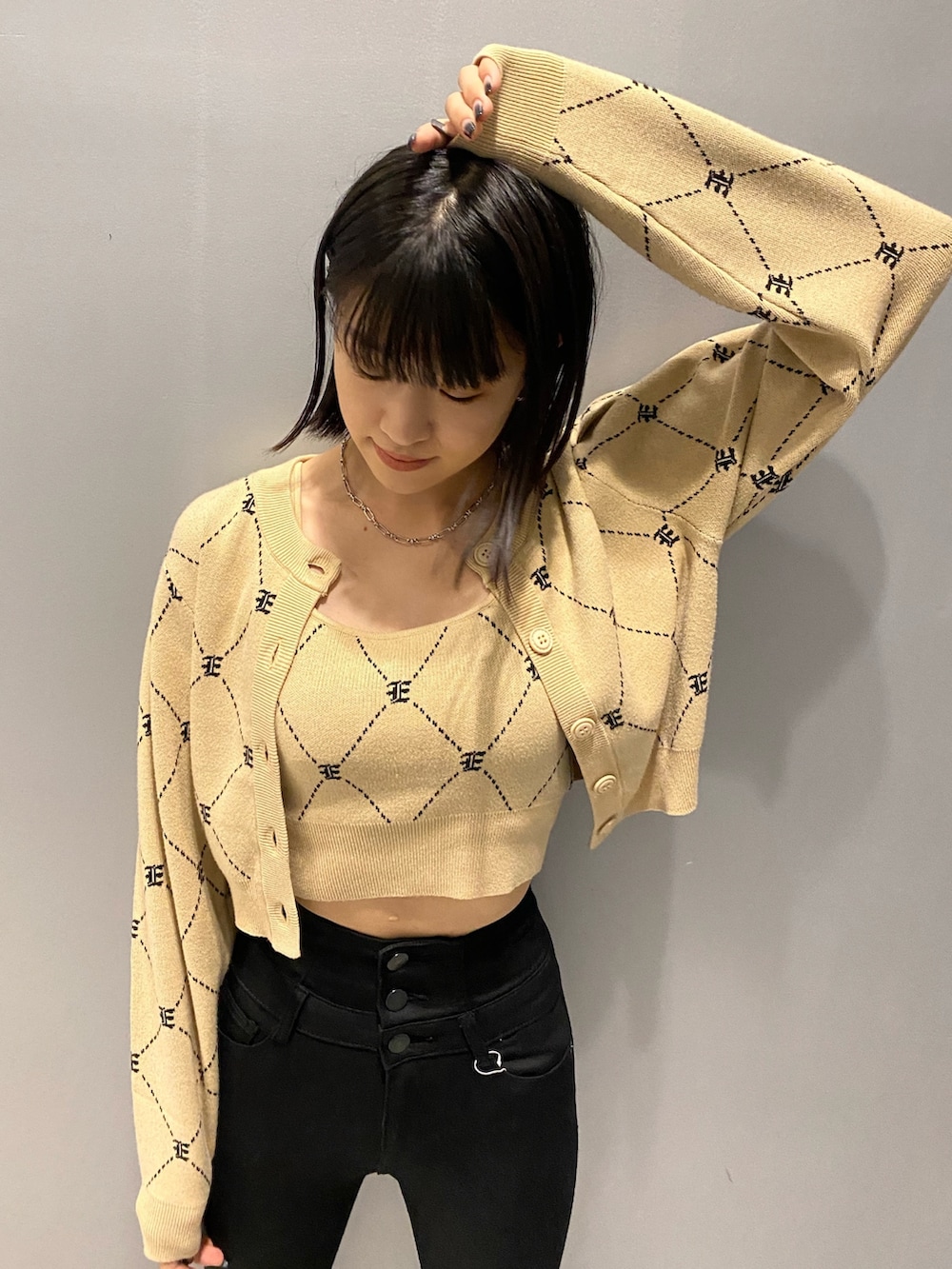 ブラック系のブーツ、ブラック系のデニムパンツ、ベージュ系のニット/セーターを着用したレディースの秋コーディネートの6枚目の写真