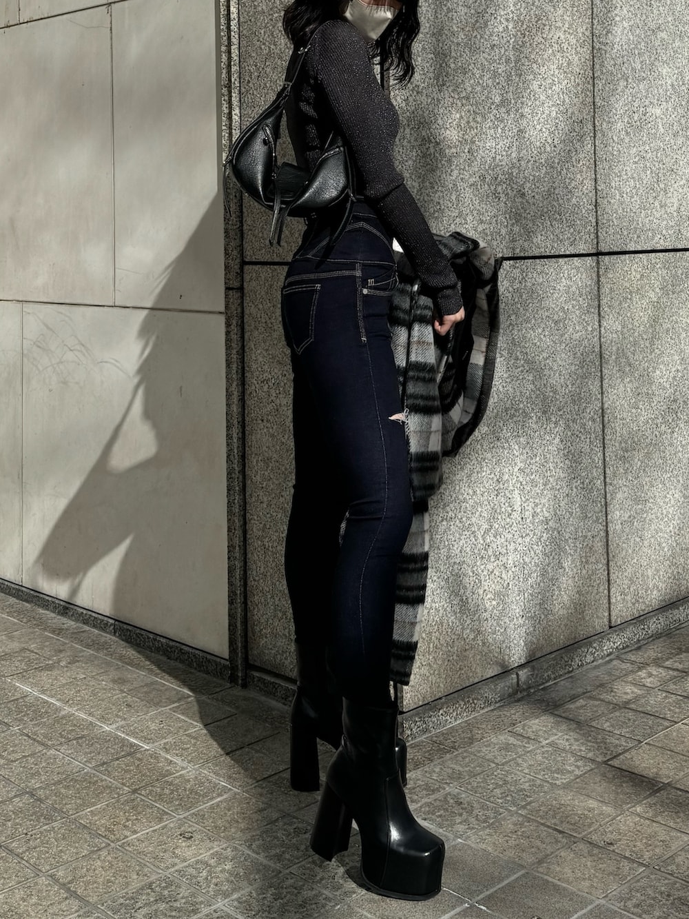 ブラック系のブーツ、ブルー系のデニムパンツ、その他のチェスターコートを着用したレディースの冬コーディネートの6枚目の写真