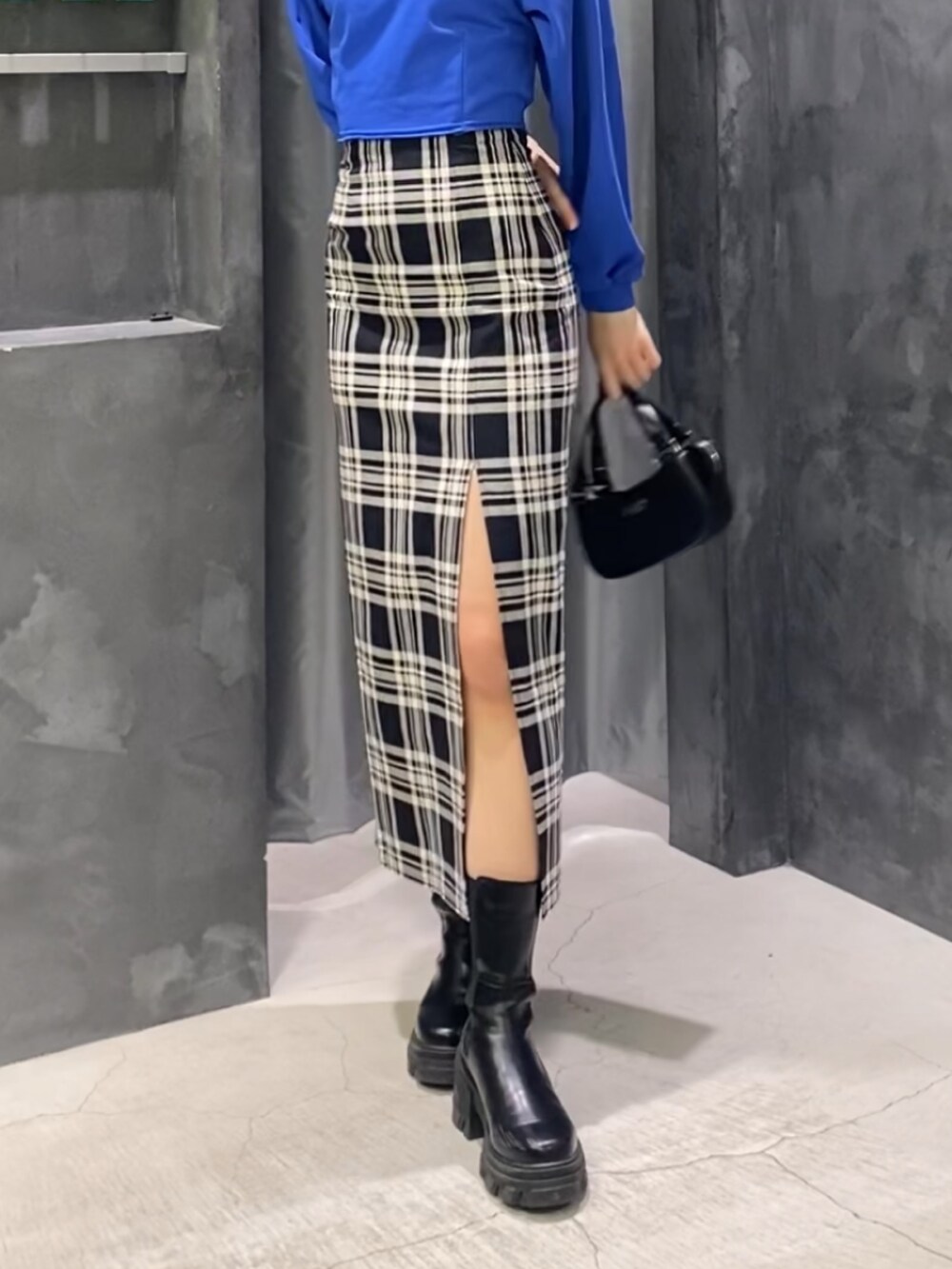 その他のスカート、ブラック系のブーツ、ブラック系のハンドバッグを着用したレディースの冬コーディネートの10枚目の写真