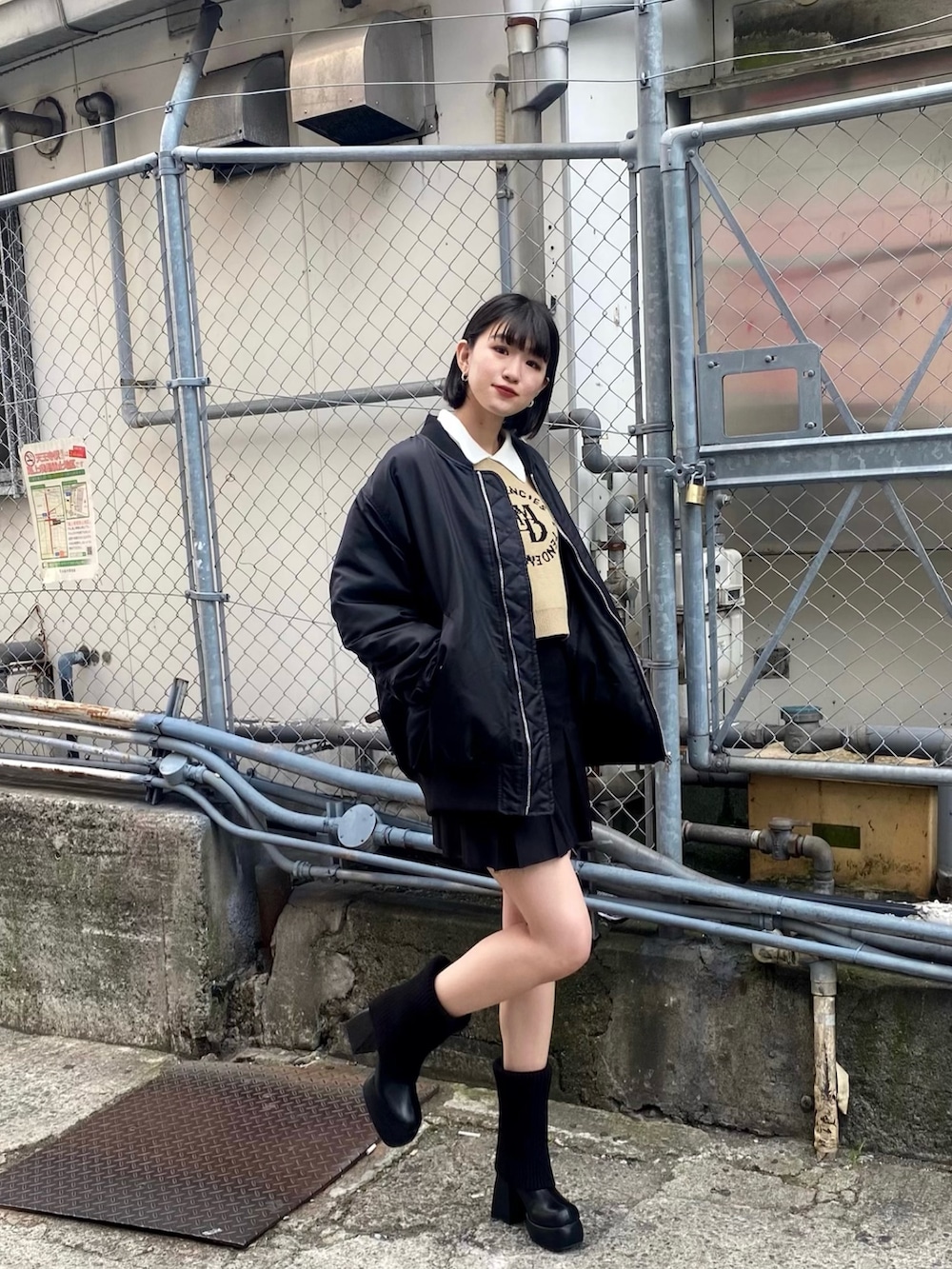 ブラック系のスカート、ブラック系のMA-1、ブラック系のブーツを着用したレディースの秋コーディネートの2枚目の写真