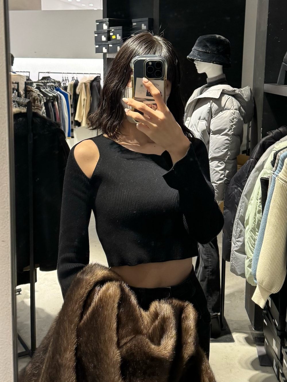 ブラック系のブーツ、ブラック系のデニムパンツ、グレー系のその他アウターを着用したレディースの冬コーディネートの6枚目の写真