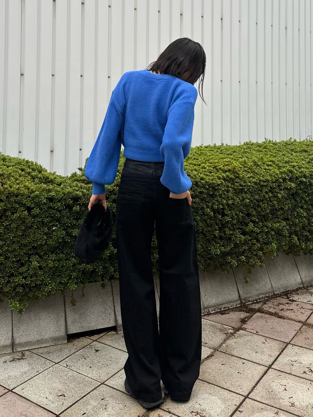 ブラック系のデニムパンツ、ブラック系のハンドバッグ、ブラック系のムートンコートを着用したレディースの冬コーディネートの8枚目の写真