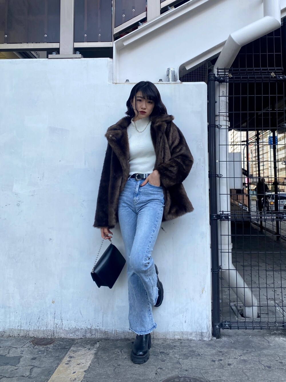 ブルー系のデニムパンツ、ブラック系のブーツ、ブラウン系のその他アウターを着用したレディースの冬コーディネートの2枚目の写真