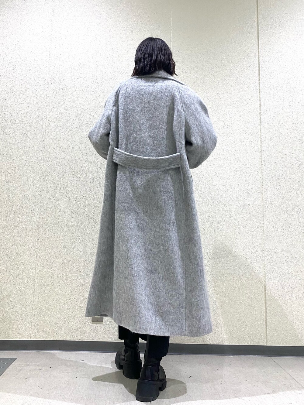 ブラック系のブーツ、グレー系のチェスターコート、ブラック系のスカートを着用したレディースの冬コーディネートの6枚目の写真