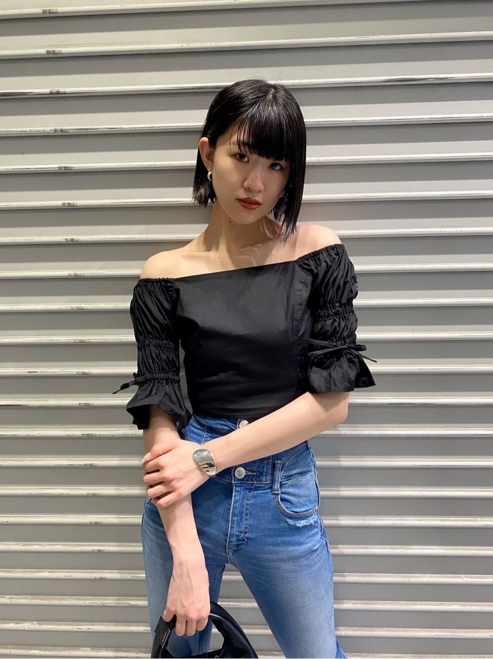 ブルー系のデニムパンツ、ブラック系のサンダル、ブラック系のシャツ/ブラウスを着用したレディースの夏コーディネートの8枚目の写真