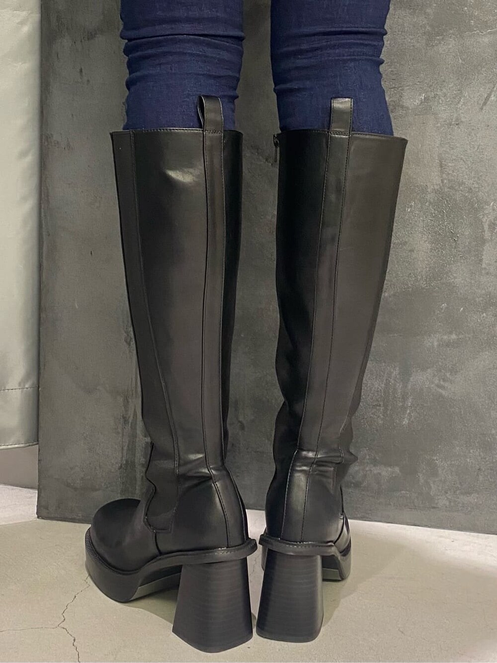 ブラック系のブーツ、その他のテーラードジャケット、ブルー系のデニムパンツを着用したレディースの秋コーディネートの6枚目の写真