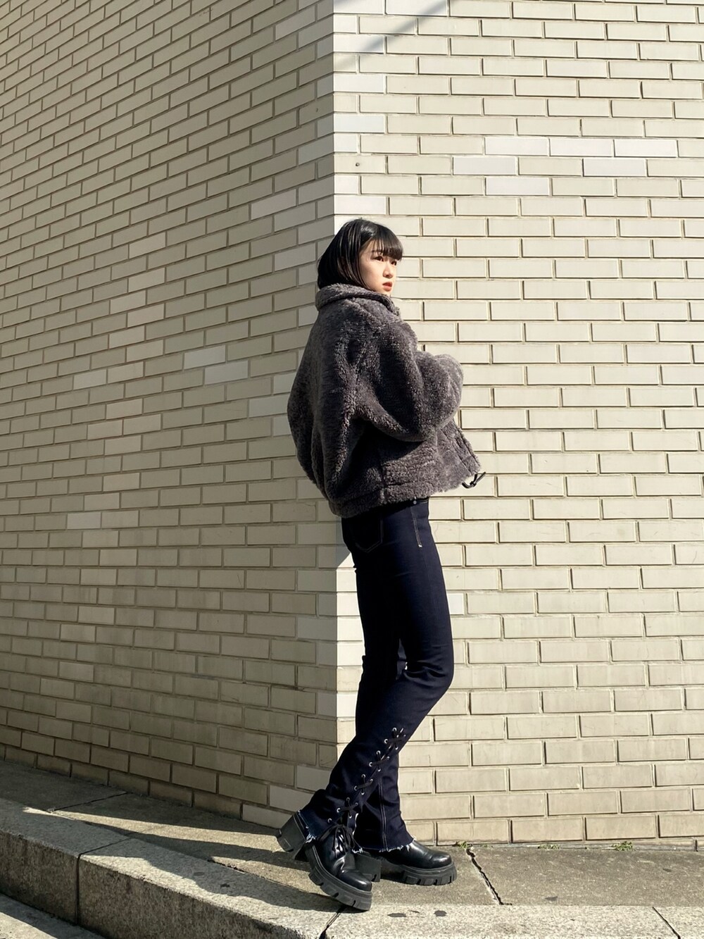 ブラック系のブーツ、ブラック系のハンドバッグ、グレー系のブルゾンを着用したレディースの冬コーディネートの2枚目の写真