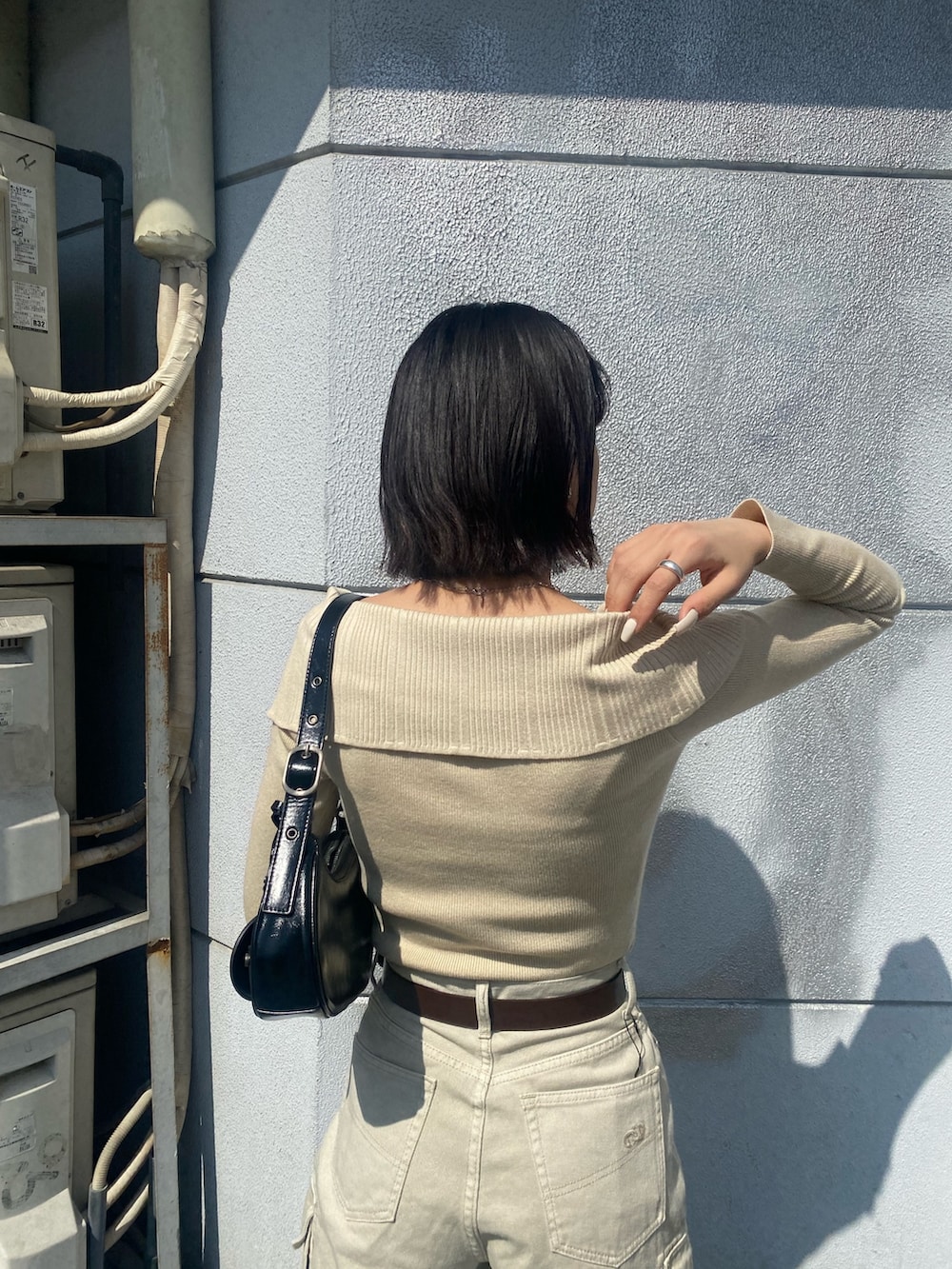 ブラウン系のブーツ、ホワイト系のデニムパンツ、ブラック系のハンドバッグを着用したレディースの春コーディネートの8枚目の写真