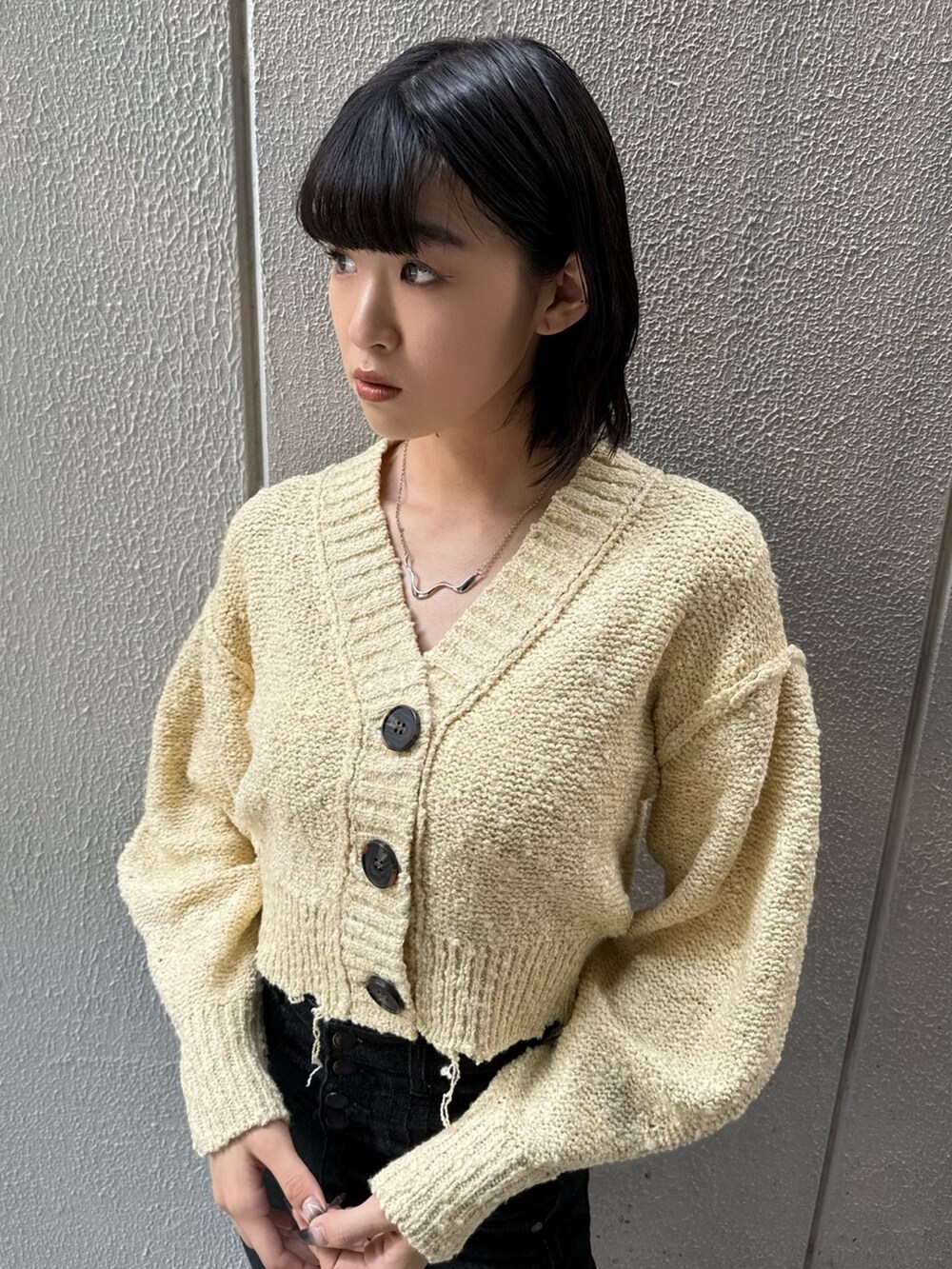 ブラック系のブーツ、ブラック系のデニムパンツ、イエロー系のカーディガン/ボレロを着用したレディースの秋コーディネートの5枚目の写真