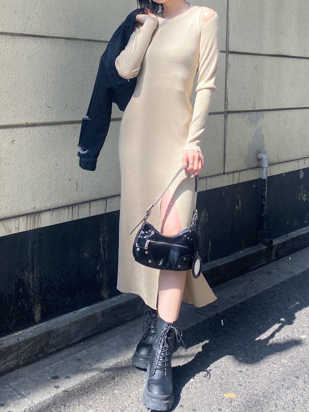 ブラック系のブーツ、ベージュ系のワンピース、ブラック系のデニムジャケットを着用したレディースの春コーディネートの4枚目の写真