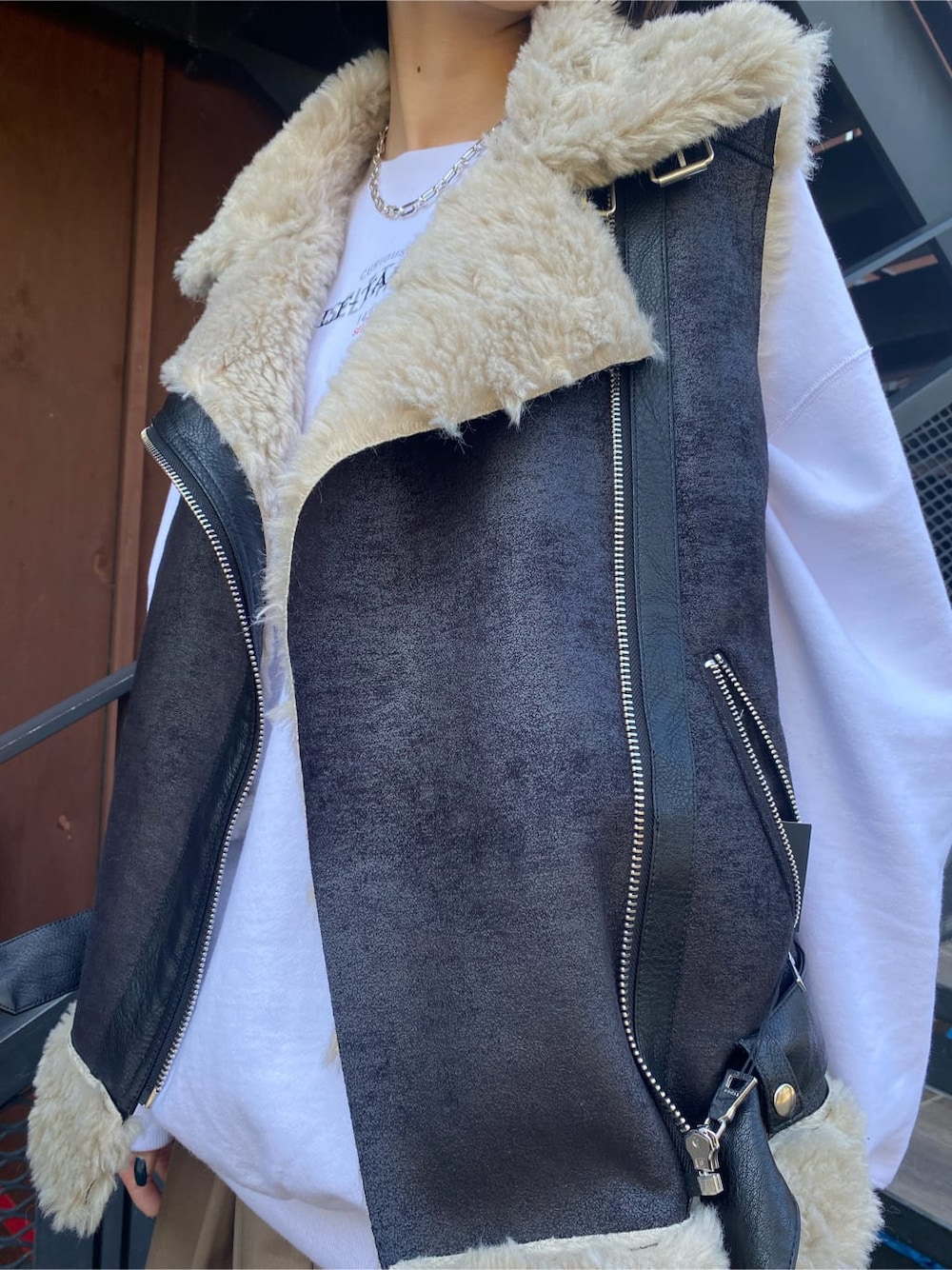 ブラック系のブーツ、ベージュ系のスカート、ブラック系のベストを着用したレディースの秋コーディネートの6枚目の写真