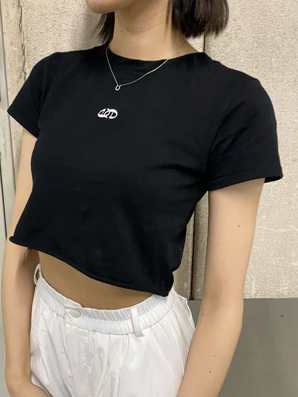 ホワイト系のその他パンツ、ブラック系のブーツ、ブラック系のTシャツ/カットソーを着用したレディースの春コーディネートの7枚目の写真