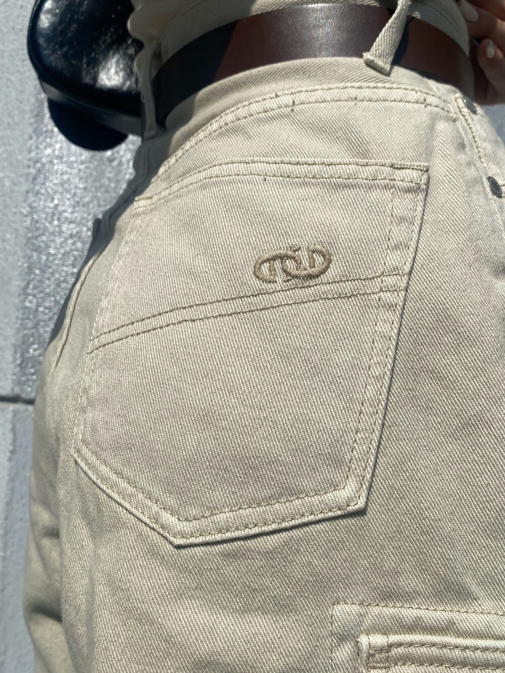 ブラウン系のブーツ、ホワイト系のデニムパンツ、ブラック系のハンドバッグを着用したレディースの春コーディネートの6枚目の写真