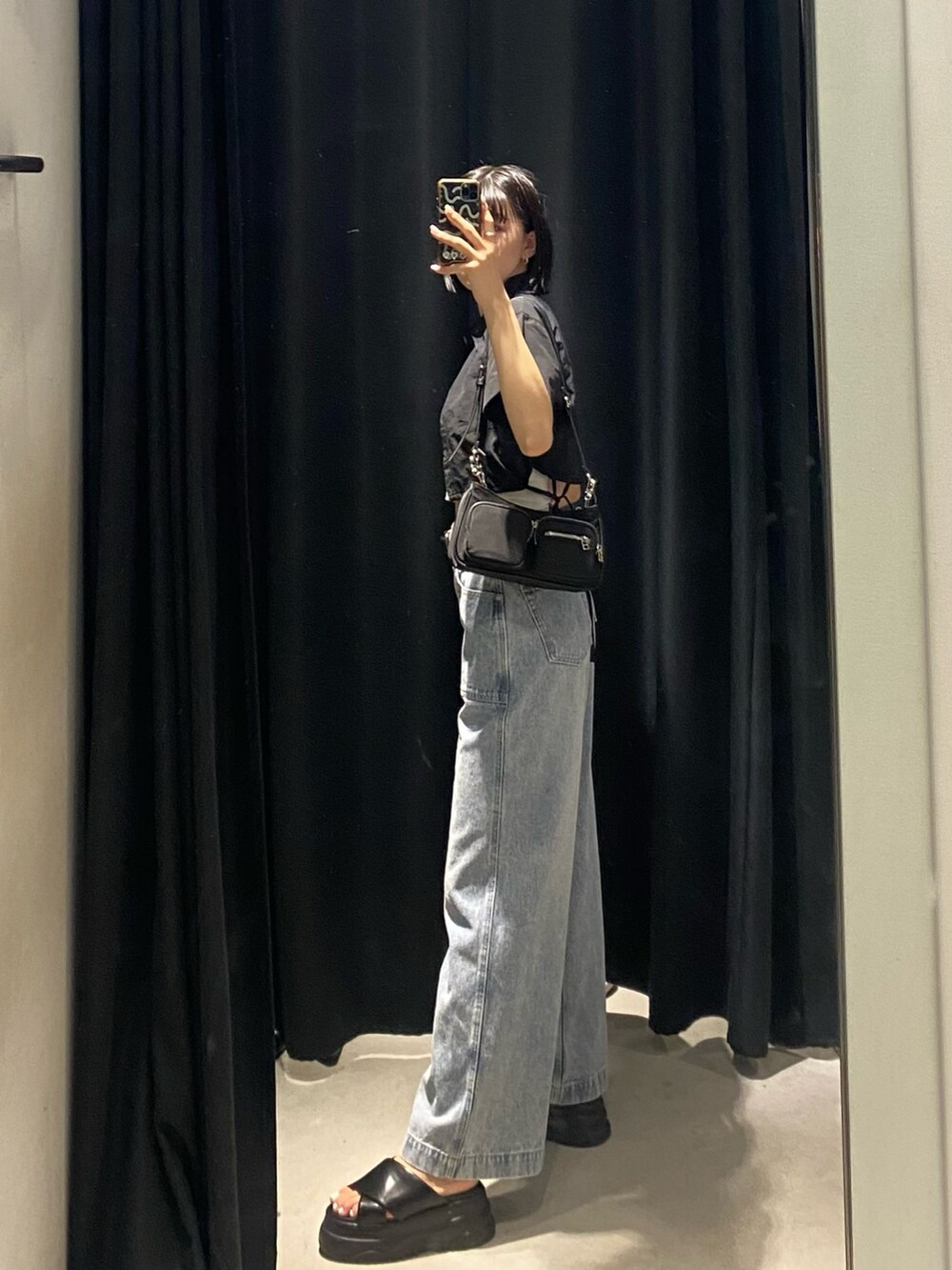 ブラック系のサンダル、ブルー系のデニムパンツ、ブラック系のシャツ/ブラウスを着用したレディースの夏コーディネートの2枚目の写真