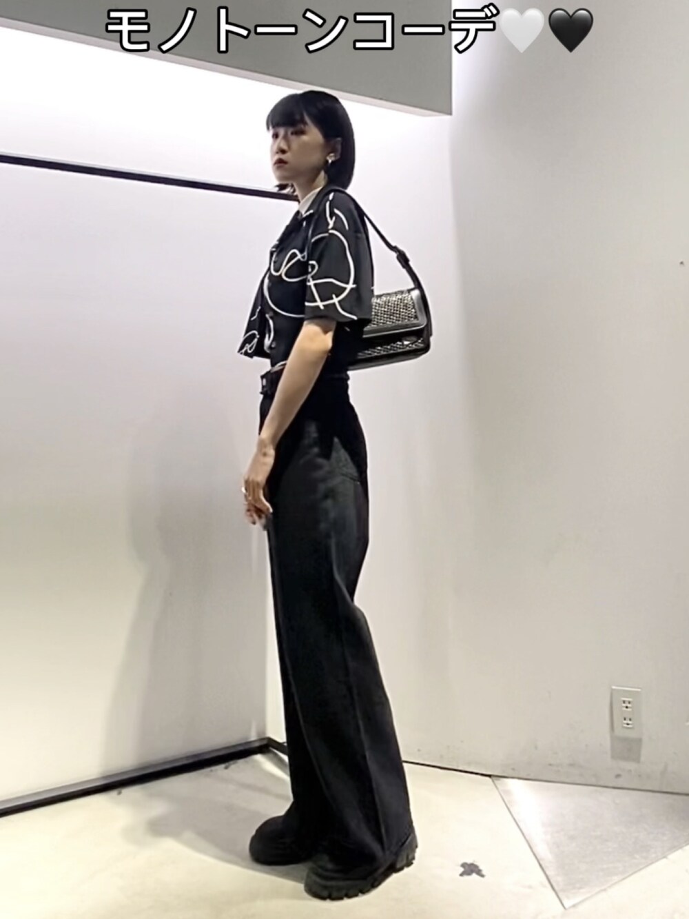 ブラック系のブーツ、ブラック系のデニムパンツ、ブラック系のショルダーバッグを着用したレディースの夏コーディネートの3枚目の写真