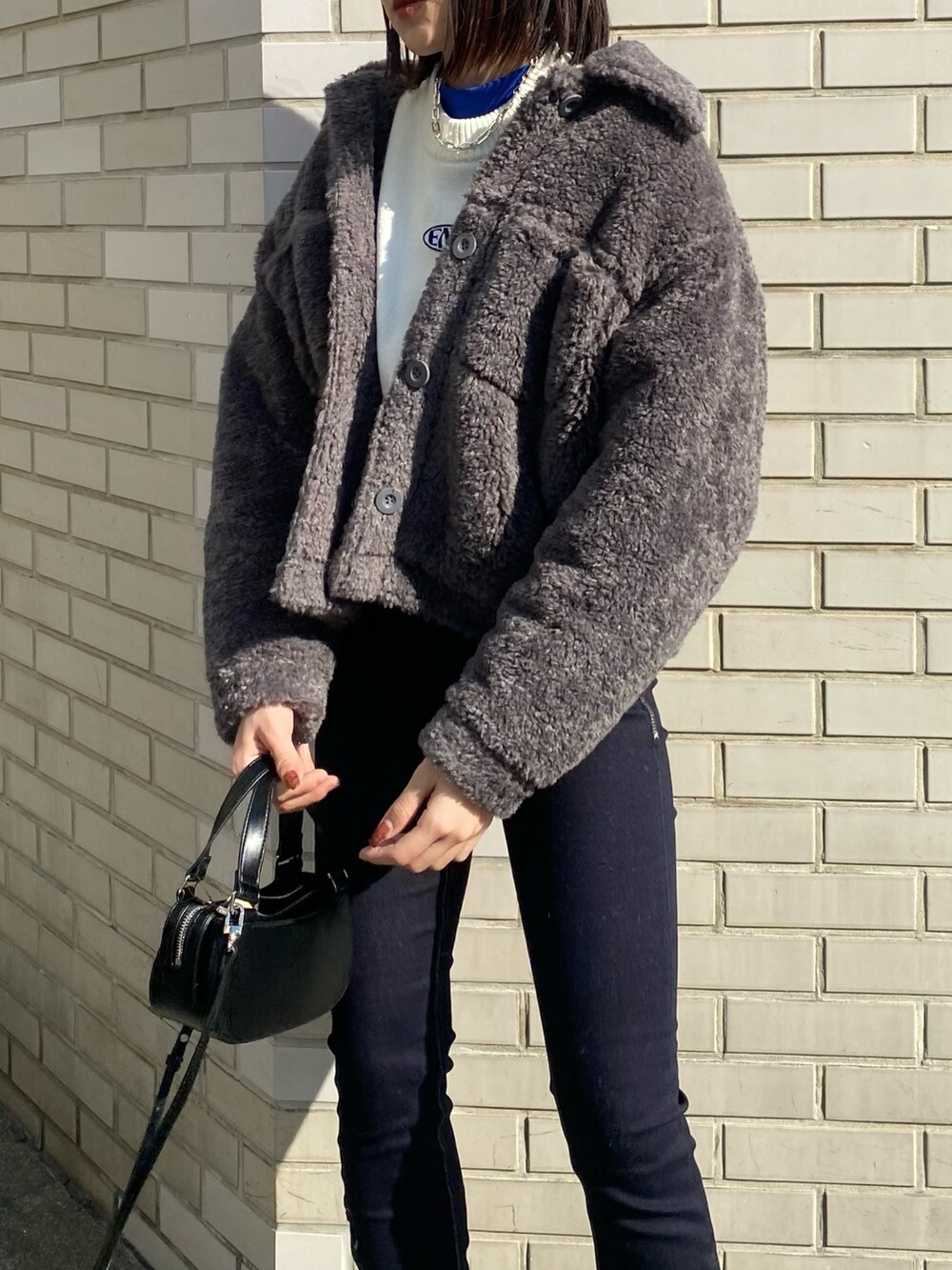 ブラック系のブーツ、ブラック系のハンドバッグ、グレー系のブルゾンを着用したレディースの冬コーディネートの5枚目の写真