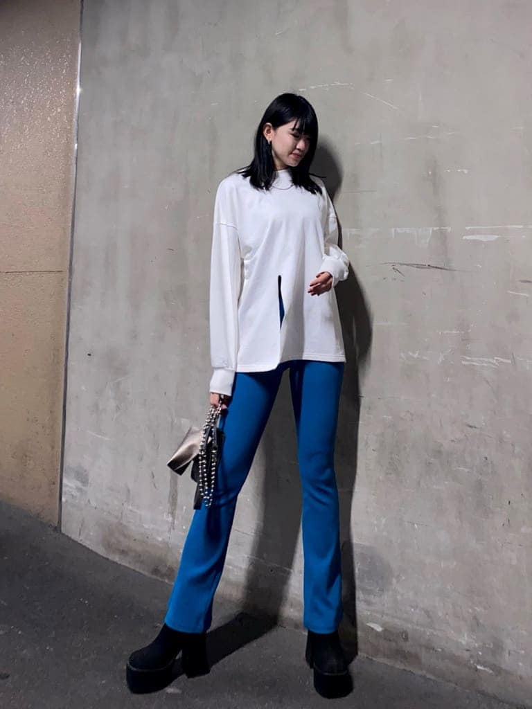 ブルー系のその他パンツ、ブラック系のブーツ、グリーン系のハンドバッグを着用したレディースの冬コーディネートの2枚目の写真