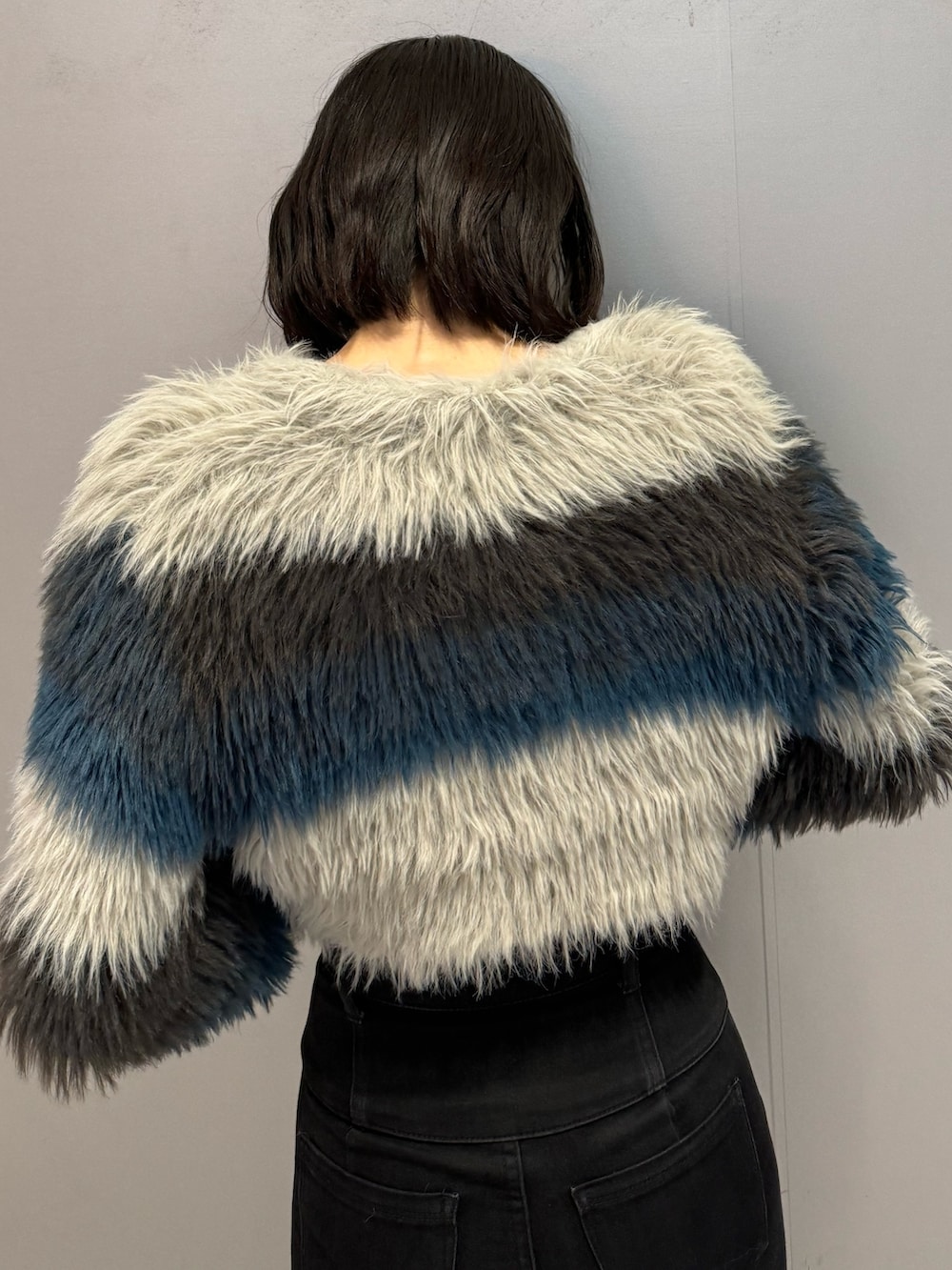ブラック系のブーツ、ブラック系のデニムパンツ、その他のニット/セーターを着用したレディースの秋コーディネートの8枚目の写真