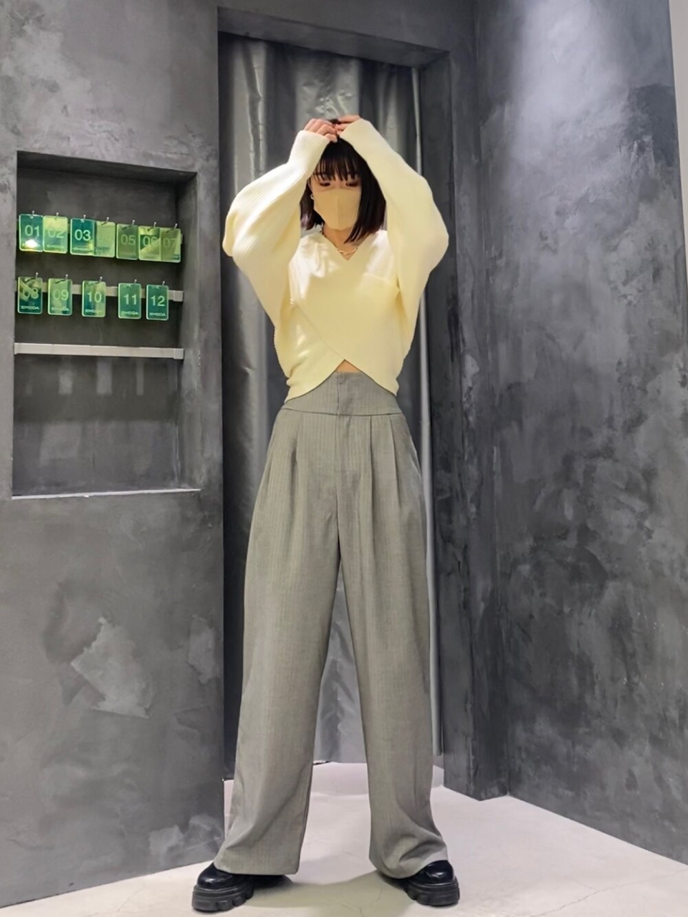 ブラック系のブーツ、グレー系のその他パンツ、ホワイト系のニット/セーターを着用したレディースの冬コーディネートの3枚目の写真