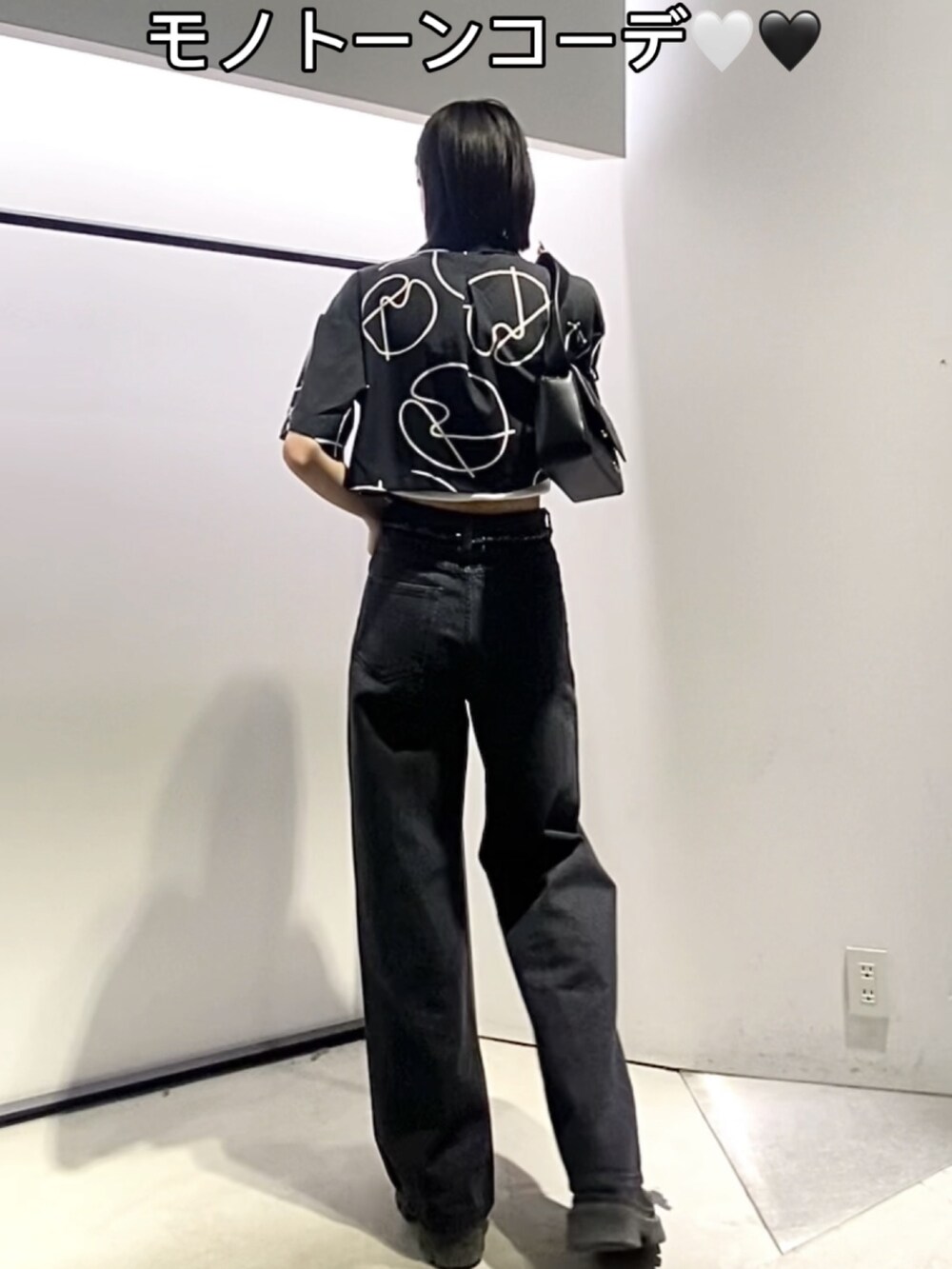 ブラック系のブーツ、ブラック系のデニムパンツ、ブラック系のショルダーバッグを着用したレディースの夏コーディネートの5枚目の写真