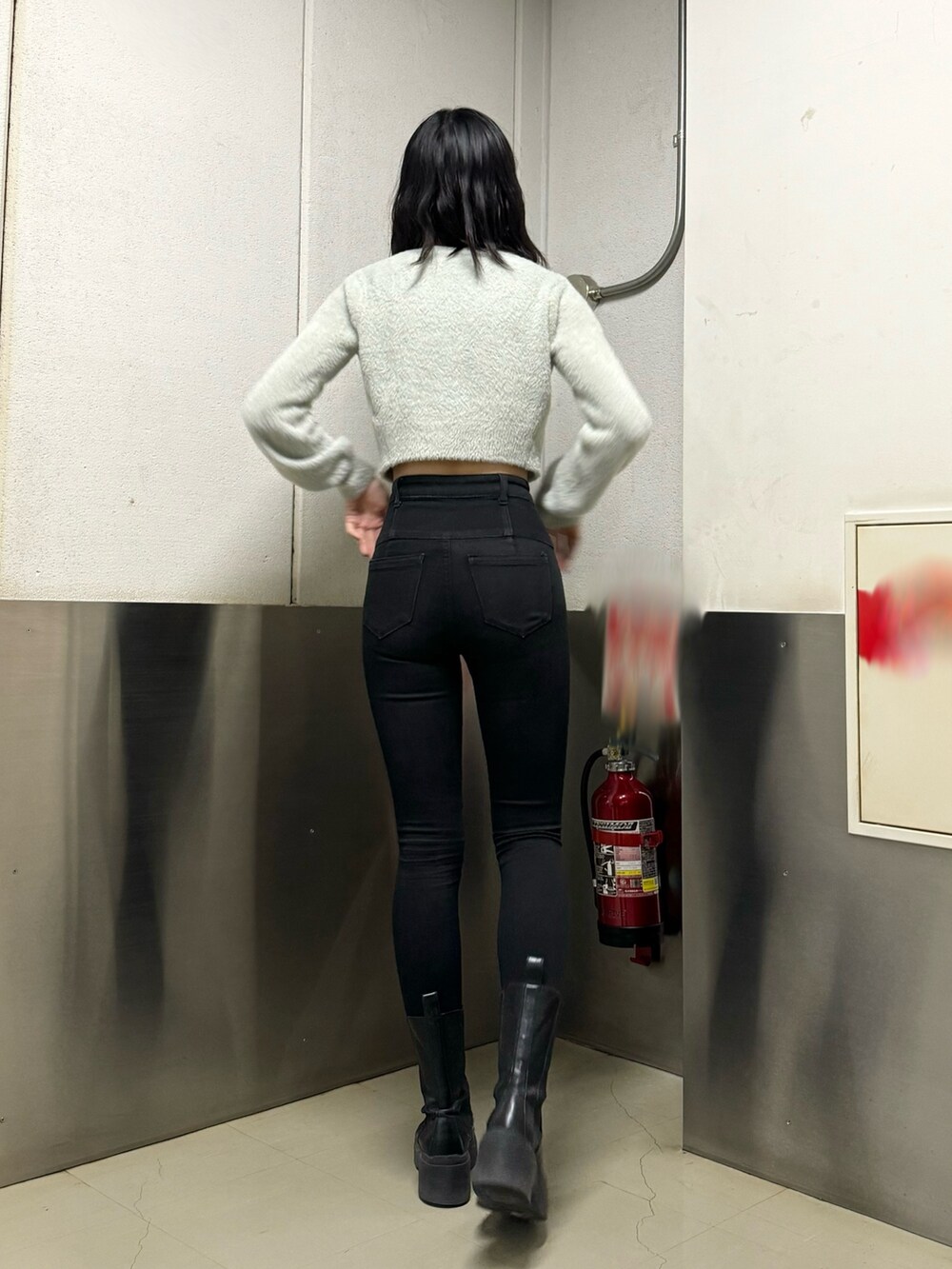 ブラック系のブーツ、ブラック系のデニムパンツ、グレー系のニット/セーターを着用したレディースの冬コーディネートの3枚目の写真