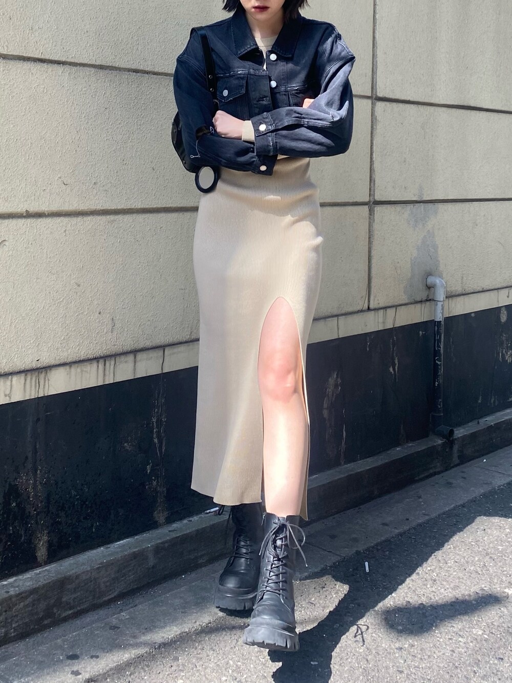 ブラック系のブーツ、ベージュ系のワンピース、ブラック系のデニムジャケットを着用したレディースの春コーディネートの8枚目の写真